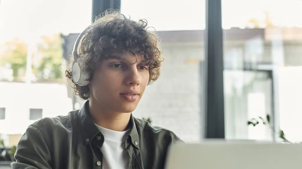 Junger Mitarbeiter mit Headset am Laptop – Symbolbild für IT-Sicherheit und moderne Arbeitsplätze, unterstützt durch Cyber-Security-Lösungen der Design und IT Agentur aus Herford snutig.