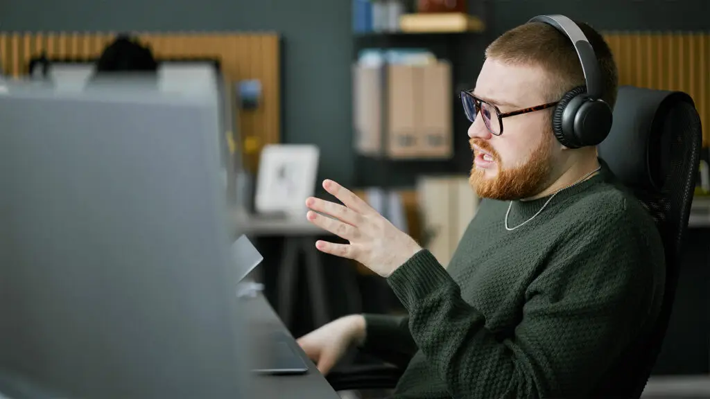 IT-Mitarbeiter mit Headset in einem virtuellen Supportgespräch – symbolisiert den ausgelagerten First Level Support durch die Design und IT Agentur aus Herford snutig.